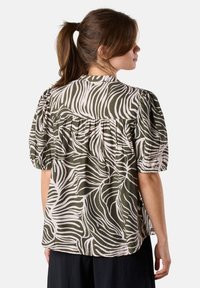 Short-sleeve blouse with a green and cream zebra stripe pattern, featuring a gathered back and pleated detailing on the shoulders.