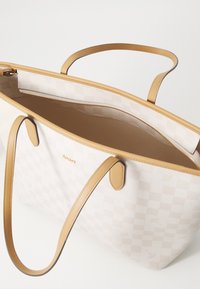 Beige kariertes Tote Bag mit tanfarbenen Lederakzenten, Reißverschluss und doppelten Schulterriemen. Glatte Textur mit dezentem Logo-Detail.