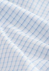 Baumwollstoff mit einem hellblauen Karomuster auf einem weißen Hintergrund; glatte Textur mit gleichmäßig verteilten horizontalen und vertikalen Linien.