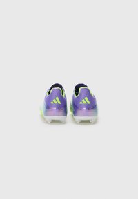 Paarse en groene voetbalschoenen met een gestructureerde afwerking, met drie diagonale strepen en een low-top ontwerp. Heldere studs op de buitenzool.