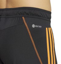 Schwarze Sportshorts mit HEAT.RDY Branding. Mit orangefarbenen Nähten und drei vertikalen orangefarbenen Streifen an der Seite. Dehnbare Stoffqualität.