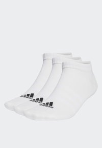 Calcetines blancos hasta el tobillo con puños acanalados, que presentan tres franjas negras y un logo negro en la punta. Material suave de mezcla de algodón texturizado.