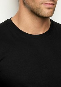 T-shirt nera in cotone con design a girocollo classico. Il tessuto appare liscio con una sottile texture, adatto per un abbigliamento casual.