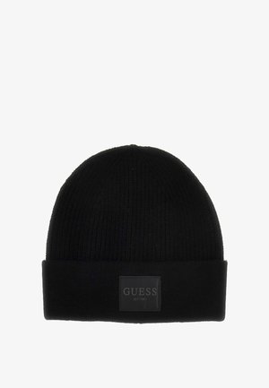 Beanie nera a coste con risvolto, caratterizzata da un'etichetta nera rettangolare embosserata con "GUESS EST.1981" in lettere bianche.