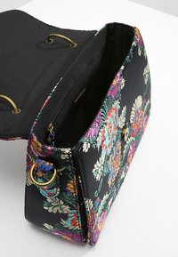 Torebka w kwiecisty wzór z czarnym materiałowym wykończeniem, złotymi elementami i wewnętrzną kieszonką na zamek. Kompaktowy design o strukturalnym kształcie.