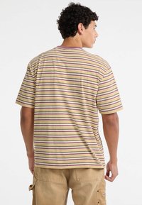 Gestreiftes T-Shirt in Gelb-, Lila- und Beigetönen, aus Baumwolle, mit entspannter Passform und kurzen Ärmeln, ausgestattet mit einem Rundhalsausschnitt.