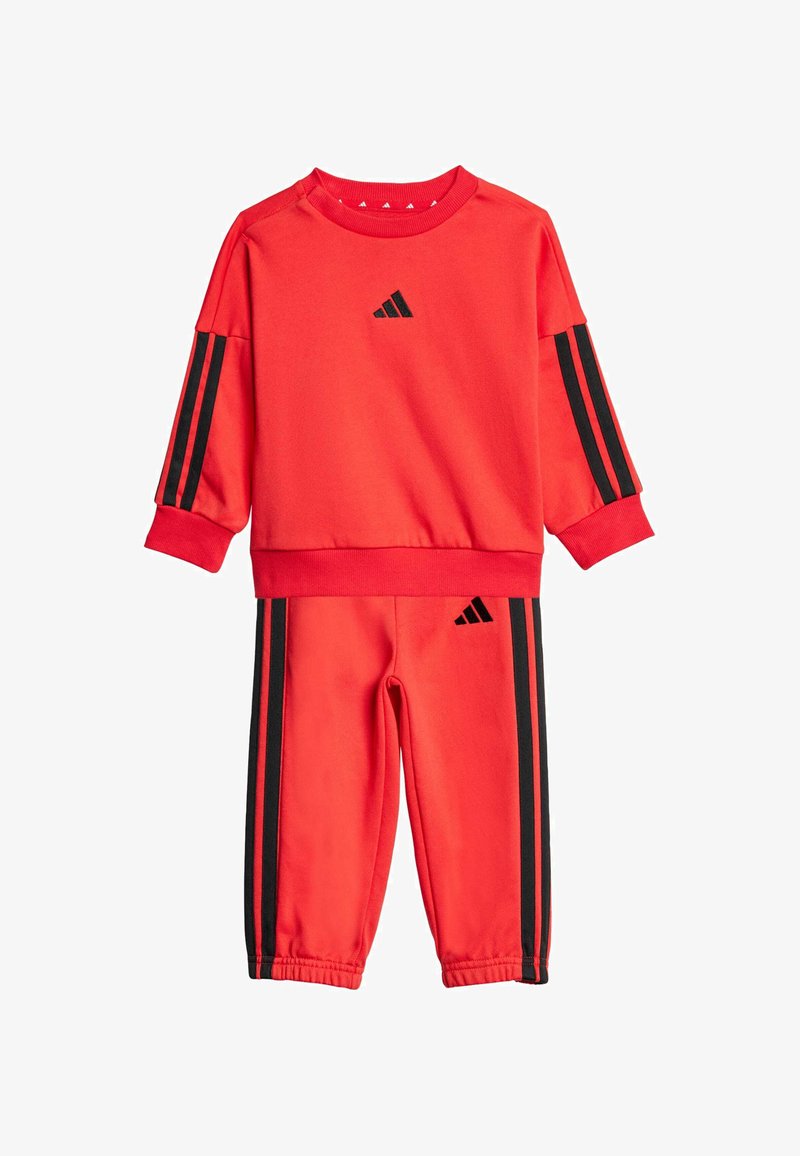 Red sweatshirt and pants set made of soft fabric, featuring black stripes on sleeves and sides, with the Adidas logo on both top and bottom.