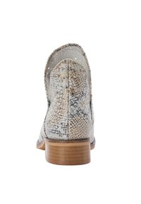 Bocanci până la gleznă de culoare deschisă, cu un aspect de piele de șarpe, având detalii perforate pe partea superioară și un toc din lemn.