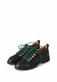 Scarpe in suede nero con lacci verdi, occhielli in metallo e una suola in gomma nera robusta. Presentano una punta rotonda e un tacco basso.