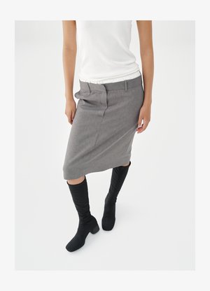 Gray pencil skirt with subtle texture, front pockets, and belt loops paired with knee-high black heeled boots. Top is white and fitted.