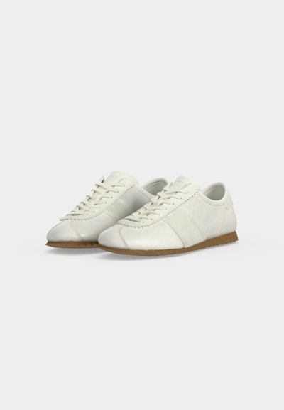 Paire de baskets basses en cuir blanc avec lacets blancs et semelles en caoutchouc marron clair sur fond blanc uni.