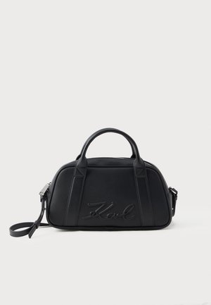 Sac à main en cuir noir avec doubles poignées supérieures, une bandoulière détachable et le logo embossé "Karl" sur le panneau avant.