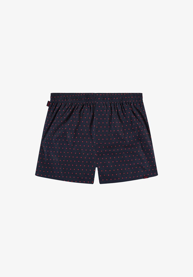 Granatowe bokserki w czerwone serduszka, z elastycznym pasem i pojedynczą kieszenią z tyłu na jednolitym białym tle.