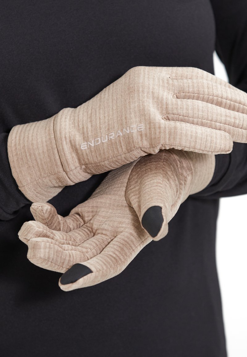 Beige Handschuhe mit strukturiertem Stoff und schwarzen Akzenten an den Fingerspitzen. Verfügt über verstärkte Nähte und das Logo "ENDURANCE" am Handgelenk.