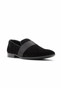 Black suede loafers with a smooth black strap across the upper, featuring a rounded toe and a low, rectangular heel.