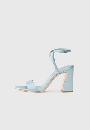 Light blue satin high-heeled sandal with a square toe, ankle strap, and a thick block heel. Smooth texture and minimalistic design.