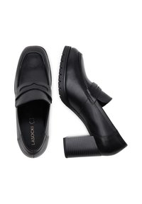 Fekete bőr sarkú mokaszin, lekerekített orral, díszítő pánttal a vamp részen és texturált tömbsarokkal. Simább felületkezelés.