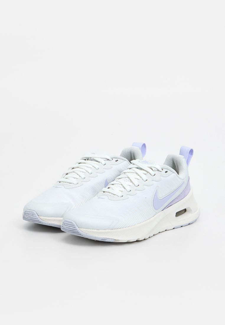 Zapatillas deportivas blancas con un upper texturizado, que presentan acentos en púrpura claro, cordones y una unidad de amortiguación de aire visible en la suela.