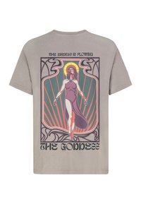 Graues Baumwoll-T-Shirt mit einem bunten Grafikmotiv einer Frau in einem fließenden Kleid, mit dem Text "DIE ENERGIE FLIEßT" und "DIE GÖTTIN."