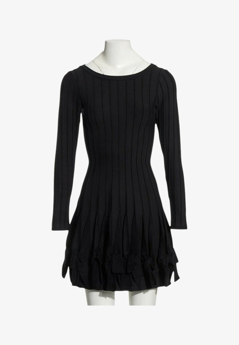 Robe noire cintrée manches longues avec côtes verticales et jupe évasée texturée, présentée sur un torse de mannequin blanc.