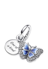 Il ciondolo a forma di farfalla in argento presenta smalto blu e accenti in zirconia cubica trasparente, attaccato a un'etichetta rotonda incisa con la scritta "Unico nel suo genere."