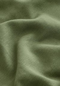 Olive green fabric with a soft, textured surface, displaying a smooth drape and subtle stretch, characterized by a uniform weave pattern.