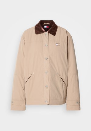 Beige jakke med en brun corduroy krave, der har trykknaplukning, to sidelommer og et lille logo patch på brystet.