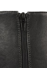 Black leather item featuring a central zip closure, textured surface, and fine stitching along the edges. Slim profile, robust zipper hardware.