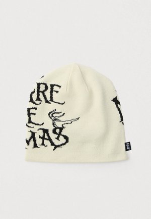 Gorro de malha em creme com texto gráfico preto e design. Apresenta uma textura macia e uma pequena etiqueta de marca na lateral.