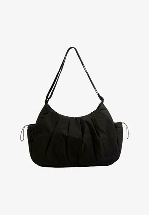 Czarna materiałowa torba na ramię z marszczonym przodem, regulowanym paskiem i kieszeniami po bokach z troczkami, prezentowana na białym tle.