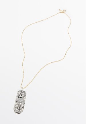 Delicata collana a catena d’oro con un pendente allungato in argento con elaborati motivi floreali e traforati con texture.