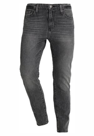 Zwart gewassen slim-fit jeans met voorste knoop, riemlussen en een ontwerp met vijf zakken, getoond op een witte achtergrond.