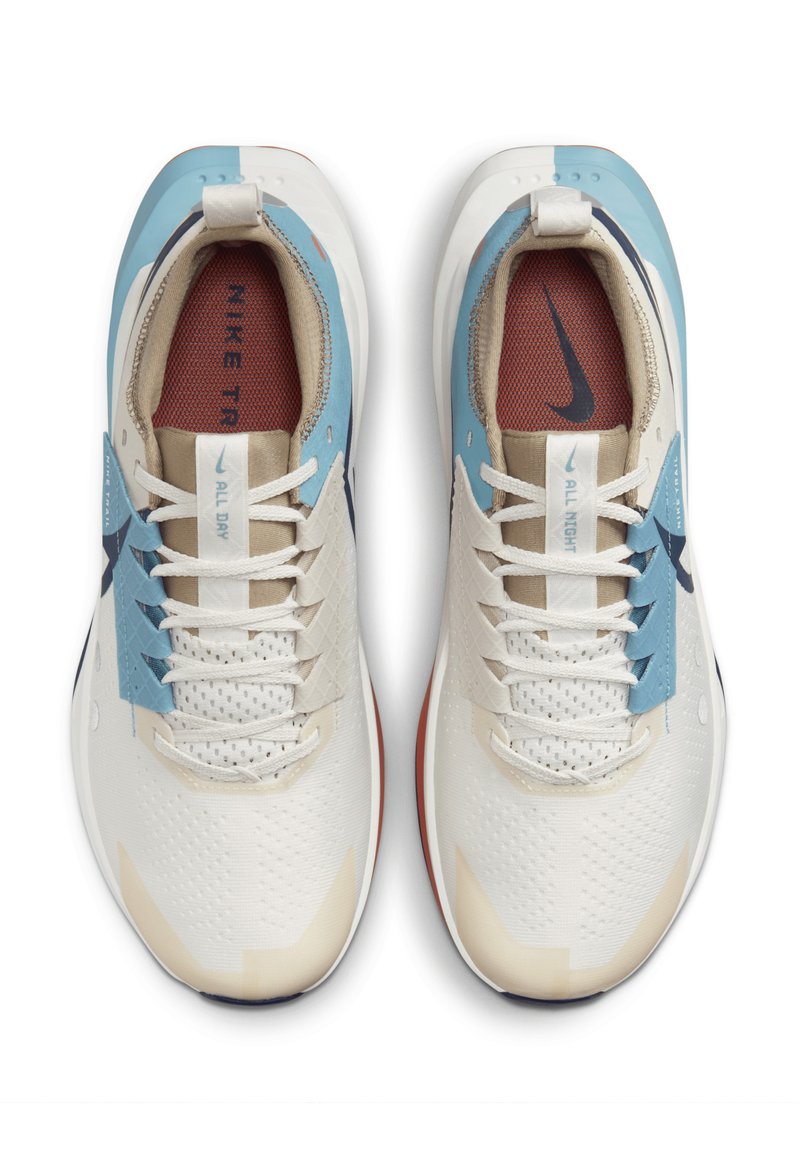 Sneakers bianchi caratterizzati da una parte superiore testurizzata con accenti blu e beige, una fodera in rete rossa e un design multi-sfaccettato sui lati.