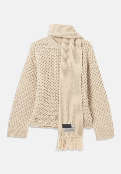 Bežna teksturirana pletena jopica s usklađenim rebrastim šalije, koji ima rese i oznaku branda, oboje položeno ravno na bijeloj pozadini.