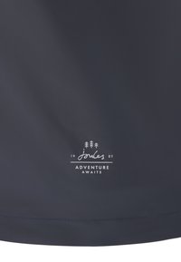 Tissu sombre avec un petit logo blanc représentant trois arbres, "joules 1989," et le texte "L'AVENTURE VOUS ATTEND" centré près du bord inférieur.