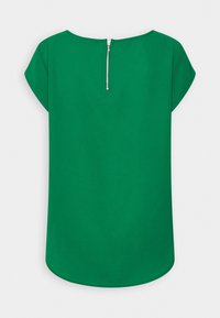 Blouse verte à manches courtes avec un col rond et une courte fermeture éclair argentée au centre du dos.