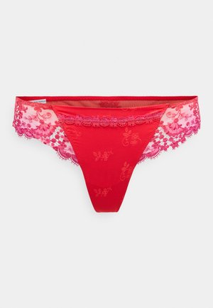 Röd trosa med broderade blommönster och en genomskinlig spetspanel. Har vågiga spetskanter i olika nyanser av rosa. Mjuk textur.