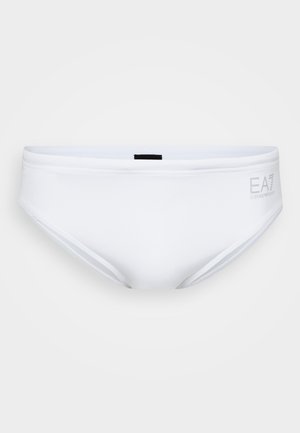 Biele plavky s hladkou textúrou, nízkym pásom a malou čiernou nálepkou na zadnej strane. Embosované logo EA7 na prednej strane.
