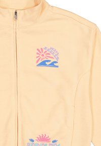 Helle Pfirsich Zip-Jacke aus weichem Stoff; mit bunten Grafiken: pinker Sonne und blauen Wellen, zusätzlich mit den Texten "WAVE SEEKER" und "sunshine mind".