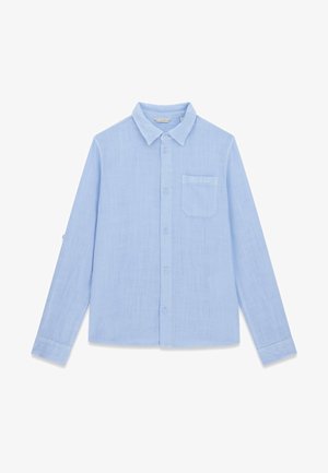 Svetlo modra srajca z dolgimi rokavi, gumbi, ovratnikom in prsno žepom, na katerem je izvezeno ime blagovne znamke "GUESS".