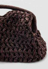 Bolso de mano tejido en marrón con un acabado texturizado, que presenta una forma estructurada y un asa resistente. El material parece natural y duradero.