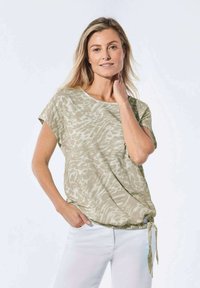 Lichtgroen t-shirt met een losse pasvorm, korte mouwen en subtiele dierenprint. Kenmerkt zich door een gerimpeld strikdetail aan de achterkant.