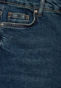 Tela de mezclilla oscura con un diseño clásico de cinco bolsillos, costuras en color naranja y un pequeño bolsillo para monedas, que muestra una textura suave.