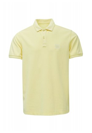Polo jaune clair à manches courtes avec deux boutons et un petit patch carré avec logo sur la poitrine gauche.