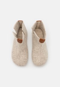 Wool slippers in light beige with a textured felt surface. Features a subtle seam and leather accents at the top for easy wear.