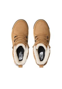 Bottes cheville en daim marron clair avec doublure en fausse fourrure synthétique, bout arrondi et semelle en caoutchouc foncé. Dotées de lacets marron et d'une languette à l'arrière du talon.