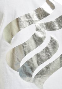 Material alb cu un model de valuri metalice argintii. Designul are o textură netedă cu accente lucioase și lățimi variate ale valurilor.