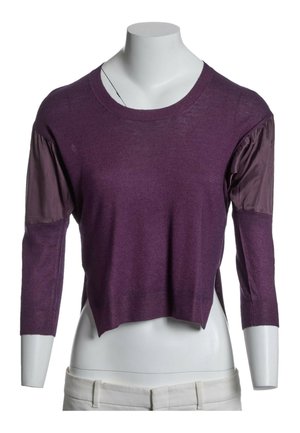Lilla langærmet sweater med opsamlede stoflapper på overarmene, vist på hvidt mannequinoverkrop iført lyse bukser.