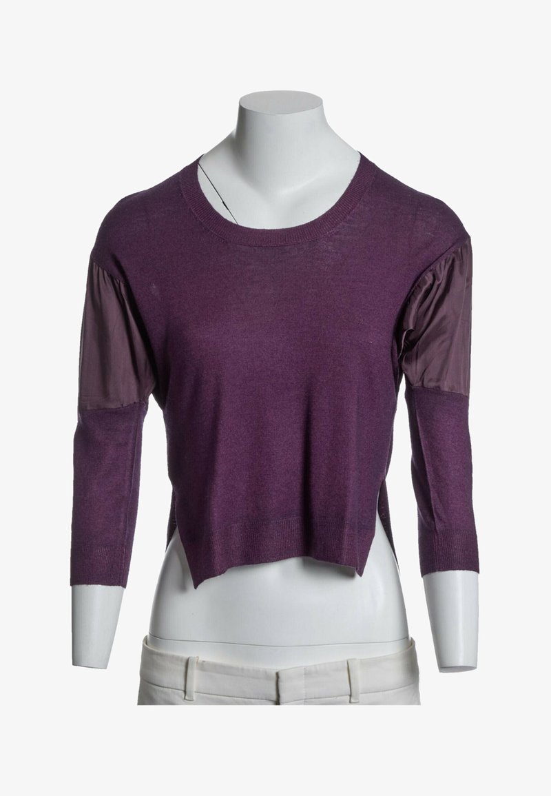 Pull violet à manches longues avec des empiècements en tissu froncés sur le haut des bras, présenté sur un buste de mannequin blanc portant un pantalon clair.