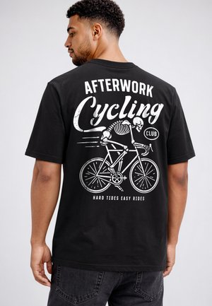 Man wearing black T-shirt with white graphic of skeleton riding bicycle and text "Afterwork Cycling Club" and "Hard tides easy rides" on back.